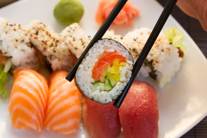 lunch with japaneese  sushi dish  with roll in chopsticks close up