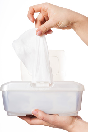 Woman drawing white wet wipe from plastic box