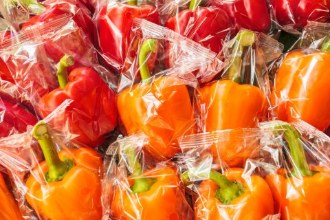 28381731 - bunch of plastic wrapped orange and red bell peppers